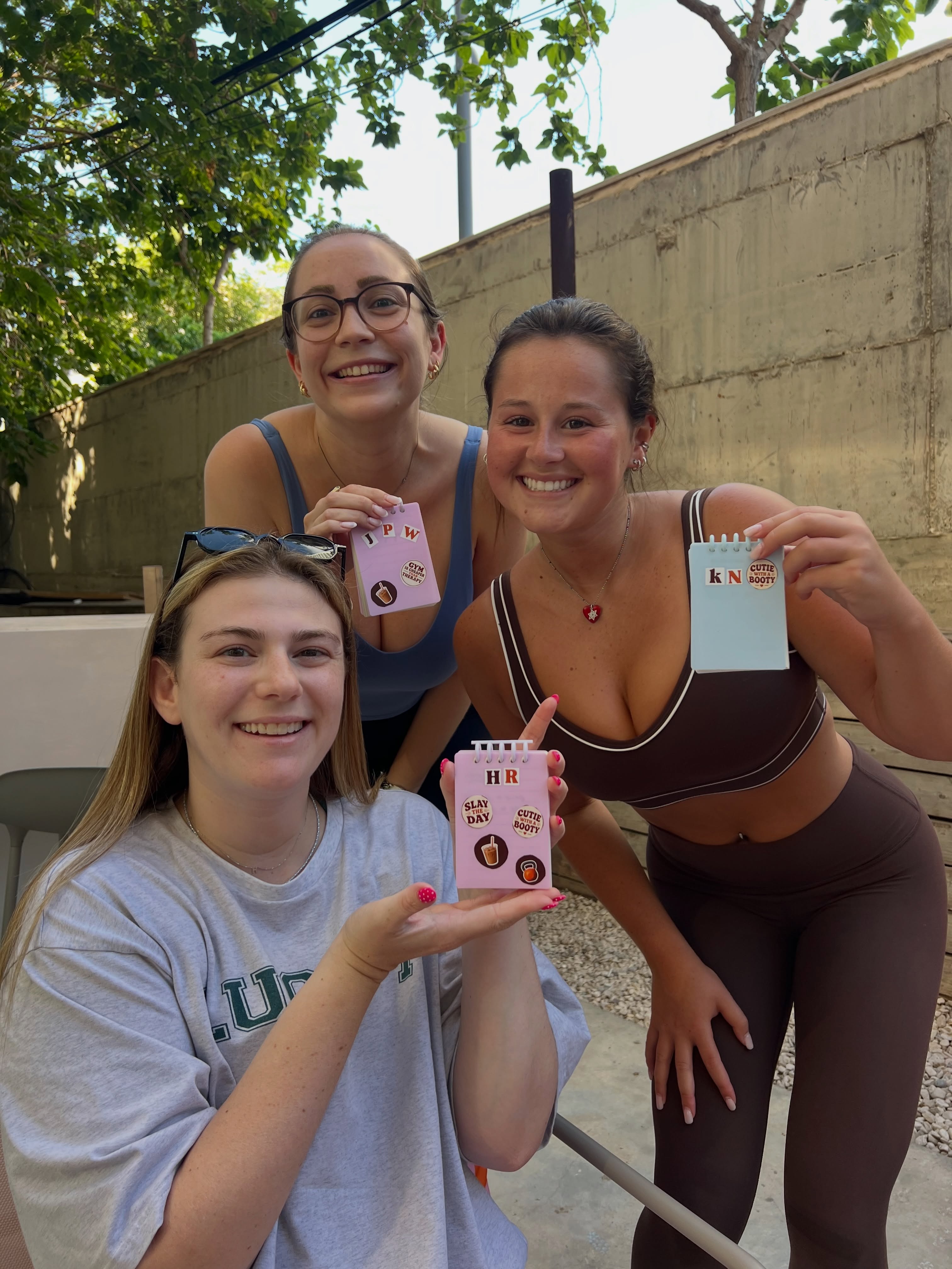 Studio members holding custom fitness notebooks
