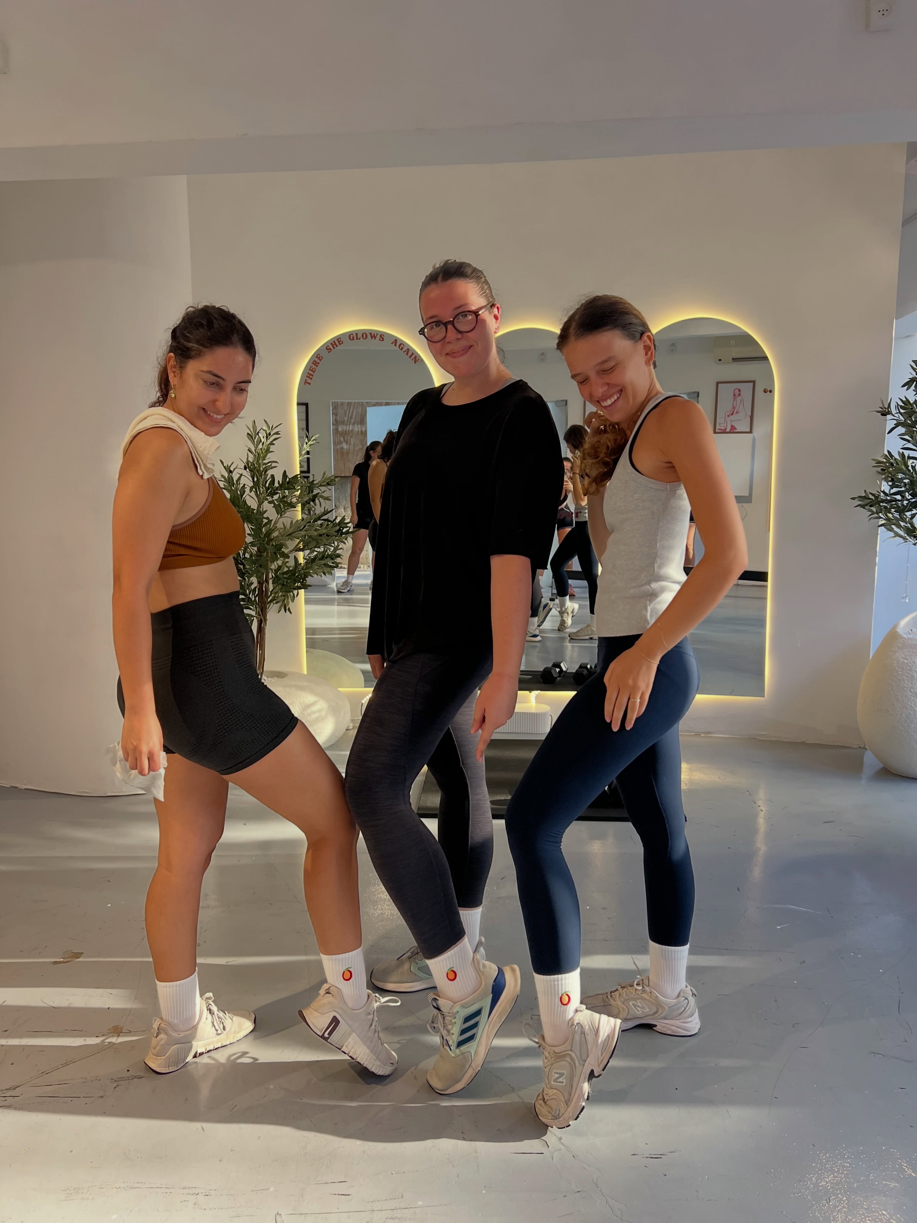 Three members showing matching peach socks in the studio